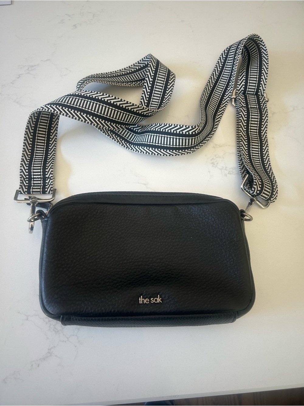 The Sak Black Pebbled Leather Crossbody with Black & White Woven Strap